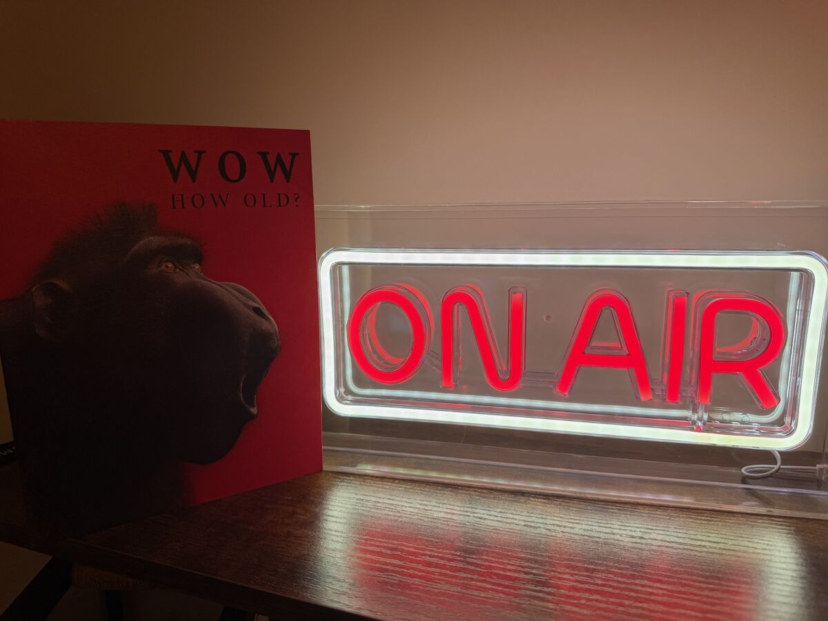 Lit red ON AIR neon sign on a shelf